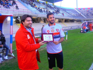 Il difensore Scudieri premiato da Fabio Cristofaro per le 100 presenze in rossoblù