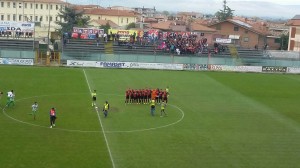 La foto del Campobasso prima dell'inizio della partita. Sullo sfondo i tifosi rossoblù ad Avezzano