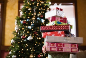 Child holding stack of Christmas gifts